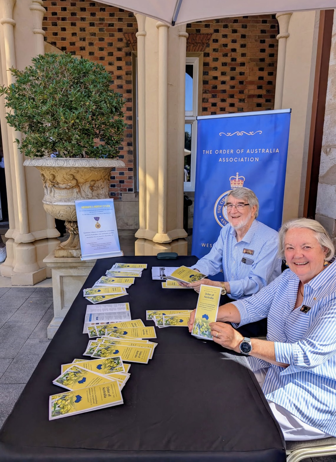 Two women sitting at a table with a table full of brochures AI-generated content may be incorrect.